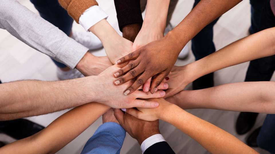 Hands all together in a circle to indicate a strong company culture
